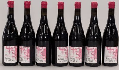 six bouteilles de vin sont alignées sur une table