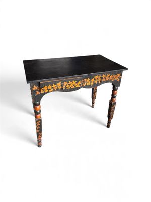 an image of a small table with a black top and gold flowers on it