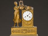 une horloge en or représentant une femme jouant de la harpe