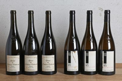 six bouteilles de vin sont alignées sur une table en bois