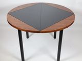 a round table with a black top and wooden legs