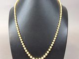 un collier de perles jaunes sur un mannequin noir