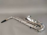 an image of a silver saxophone sitting on top of a white surface