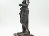 an antique bronze statue of a woman holding a bird on a marble base
