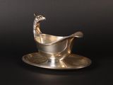 a silver plate with a spoon and saucer on it