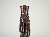 une statue en bois représentant un homme coiffé d'une couronne