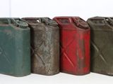 four old gas cans are lined up in a row