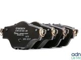 four black brake pads with gold hardware on a white background