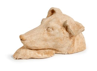 une statue représentant un chien couché sur une surface blanche