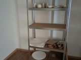 a shelf with plates and bowls on it in the corner of a room
