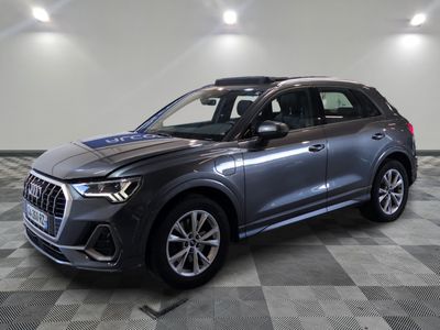 un SUV Audi gris garé sur un sol à damier dans un showroom