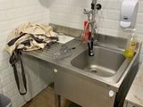 a sink and a trash can in a small room