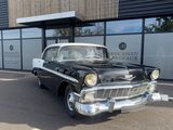 a black and white car parked in front of a building