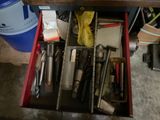 un tiroir rempli d'outils et des outils posés sur une table