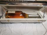 une bouteille de vin dans un coffret en argent, posée sur une table