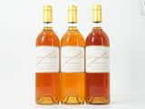 trois bouteilles de vin posées les unes à côté des autres sur une surface blanche