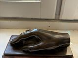 a statue of a hand resting on a wooden block