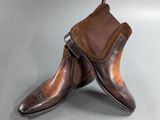 two pairs of brown leather shoes on a grey surface