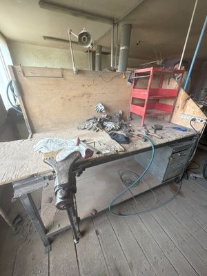 une photo d'un établi dans un atelier, avec des outils