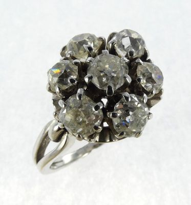 an image of a diamond cluster ring on a white surface
