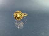 bague plaquée or ornée d'un visage de lion sur une surface brillante