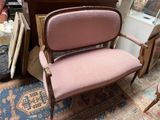 une chaise rose qui se trouve dans une pièce