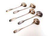 six spoons are lined up in a row on a white surface