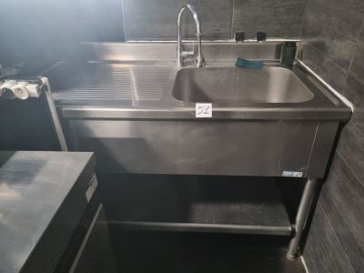 un évier en acier inoxydable dans le coin d'une salle de bains