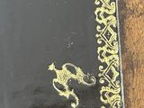 a black and gold book with a picture of a bird on it