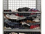 une cage métallique remplie de nombreux vêtements sur fond blanc