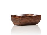 the wooden bowl is shaped like a boat on a white surface