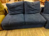 two blue couches sitting on a wooden floor in a room