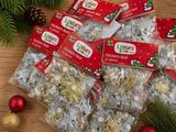 many bags of christmas candy sitting on a table
