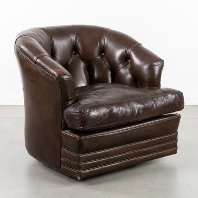 une photo d'un fauteuil en cuir marron dans une pièce blanche