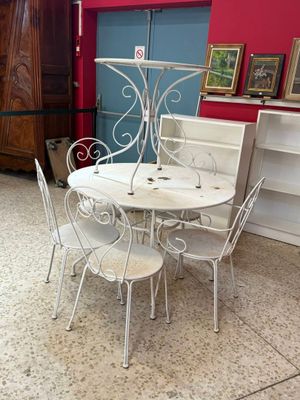 une table et des chaises blanches dans une pièce aux murs rouges
