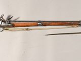a wooden rifle with a metal handle on a white background