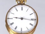 une montre de poche en or avec des chiffres romains sur le cadran