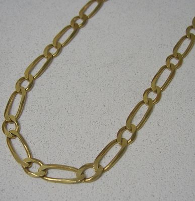 Collier à chaîne plaquée or avec des maillons ovales sur un fond blanc