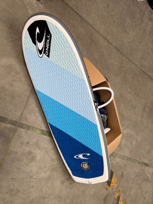 une planche de surf bleue et blanche posée par terre