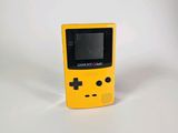 une petite Game Boy jaune posée sur une surface blanche