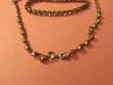 un collier composé de perles de verre vertes, porté par un mannequin