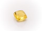 a close up of a yellow diamond on a white surface