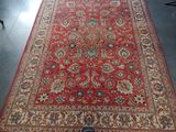 Un tapis persan ancien est exposé dans une pièce