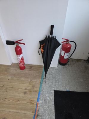 un extincteur posé à côté d'une borne d'incendie sur le sol