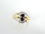 gros plan d'une bague en or avec une pierre bleue et des diamants