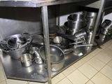 many pots and pans sitting on the shelf in the kitchen