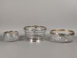 a group of three silverplated dishes and cups