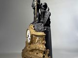 a statue of a man standing on top of a clock