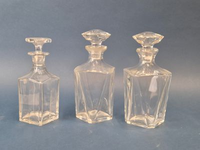 trois bouteilles en verre transparent posées les unes à côté des autres sur une surface bleue