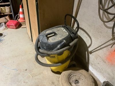 a yellow and black vacuum sitting on the floor next to a wall